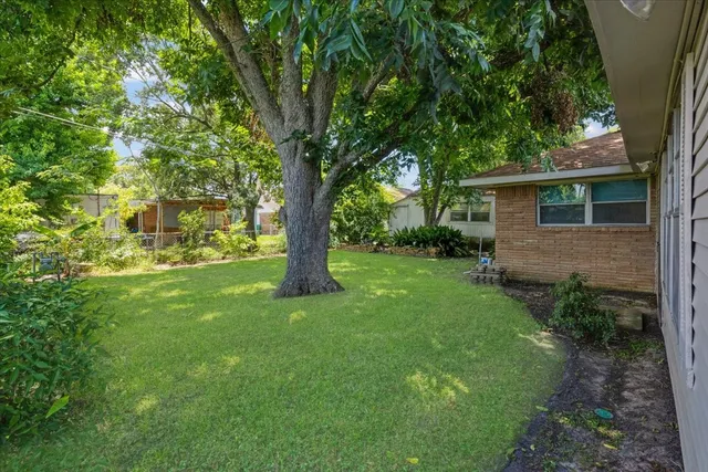 a view of a house with a big yard and large trees