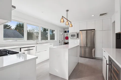 a kitchen with a refrigerator a stove and a sink