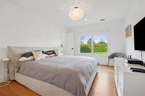 a bedroom with bed tv and window