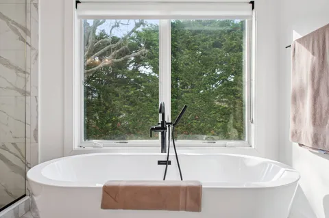 a white bath tub sitting in front of a window