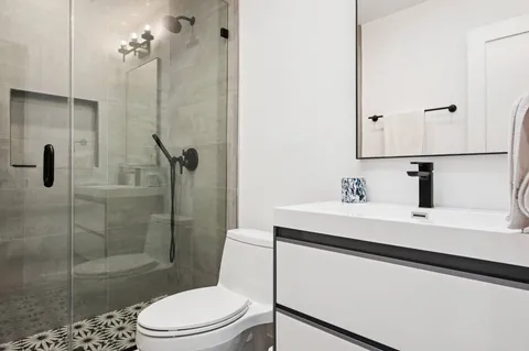 a bathroom with a sink a toilet and shower