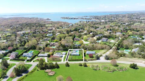 an aerial view of residential houses with outdoor space and trees