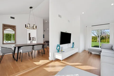 a living room with furniture a flat screen tv and a large window
