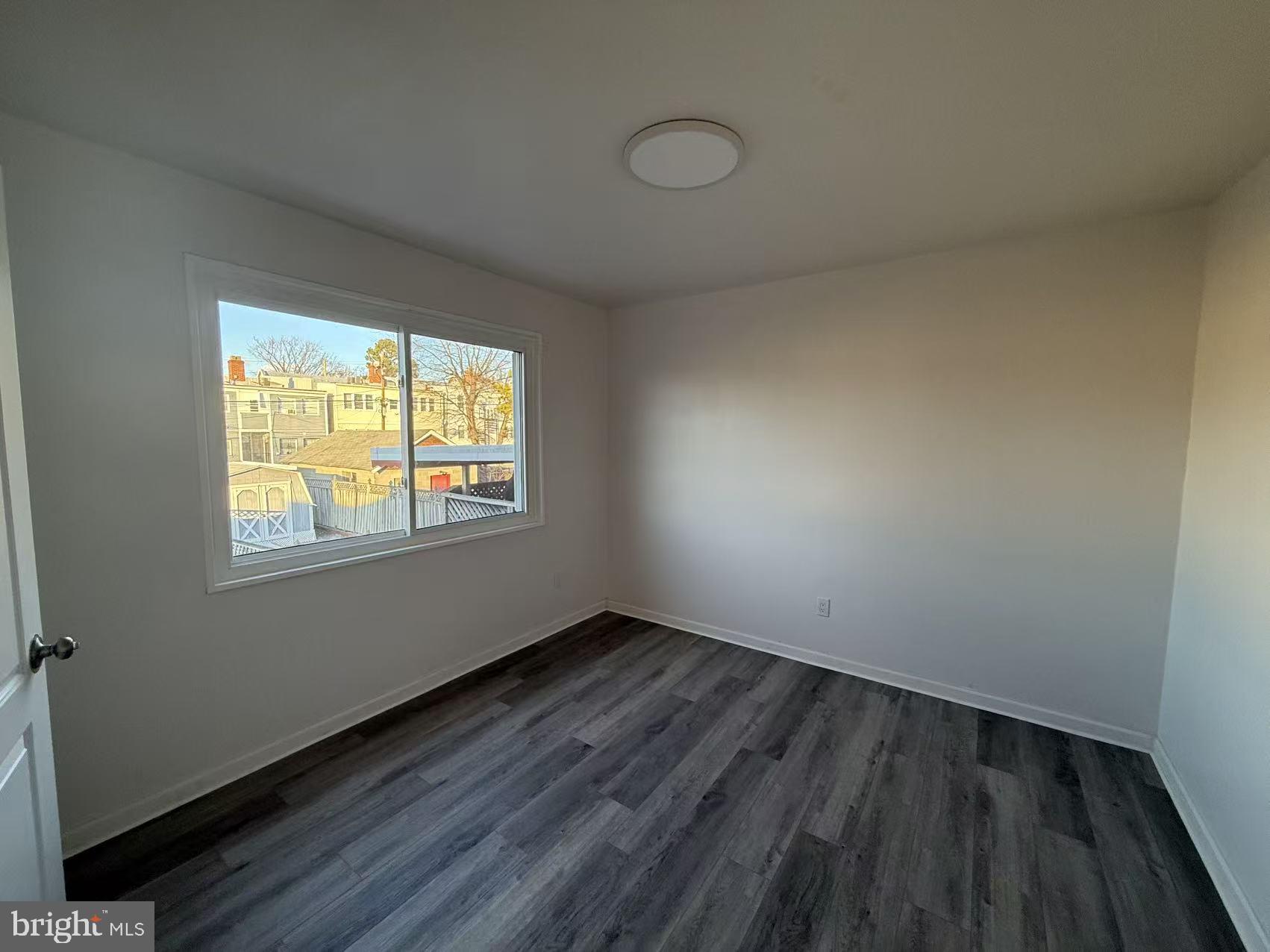 1328 W Street Northeast Washington, DC 20018 - Photo 12 of 25 a view of an empty room with wooden floor and a window