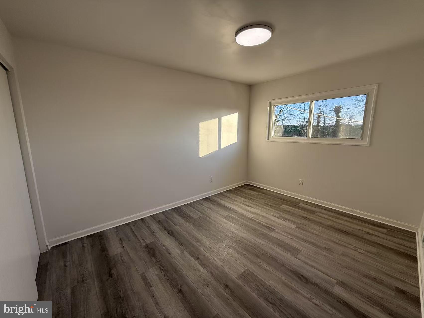 1328 W Street Northeast Washington, DC 20018 - Photo 13 of 25 an empty room with wooden floor and windows