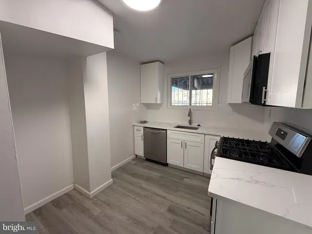 a kitchen with a sink a stove and cabinets