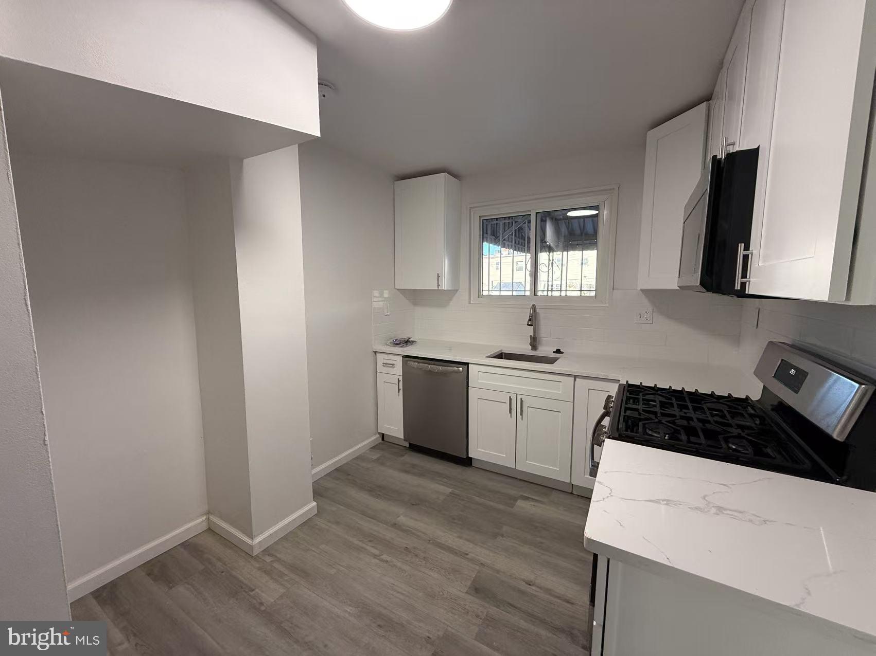 1328 W Street Northeast Washington, DC 20018 - Photo 6 of 25 a kitchen with a sink a stove and cabinets