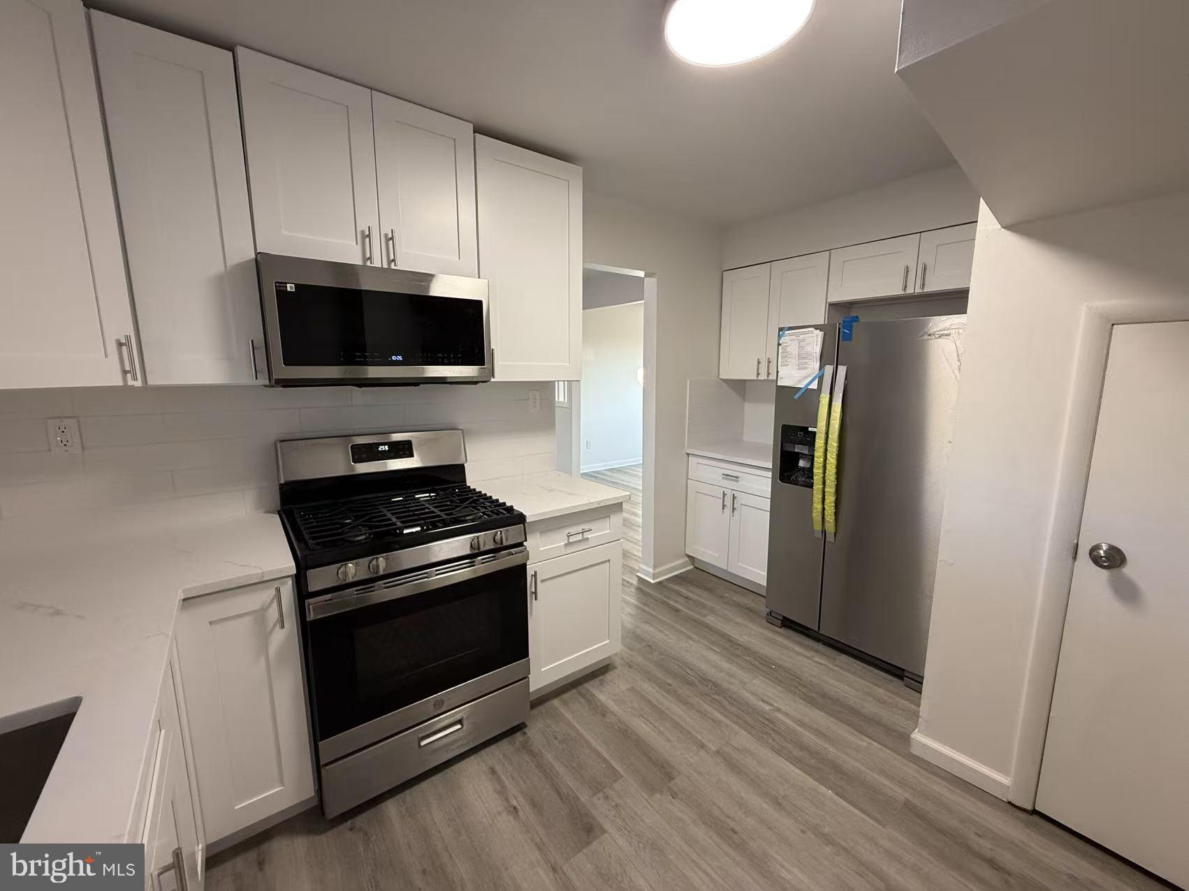 1328 W Street Northeast Washington, DC 20018 - Photo 9 of 25 a kitchen with a stove a refrigerator and a microwave