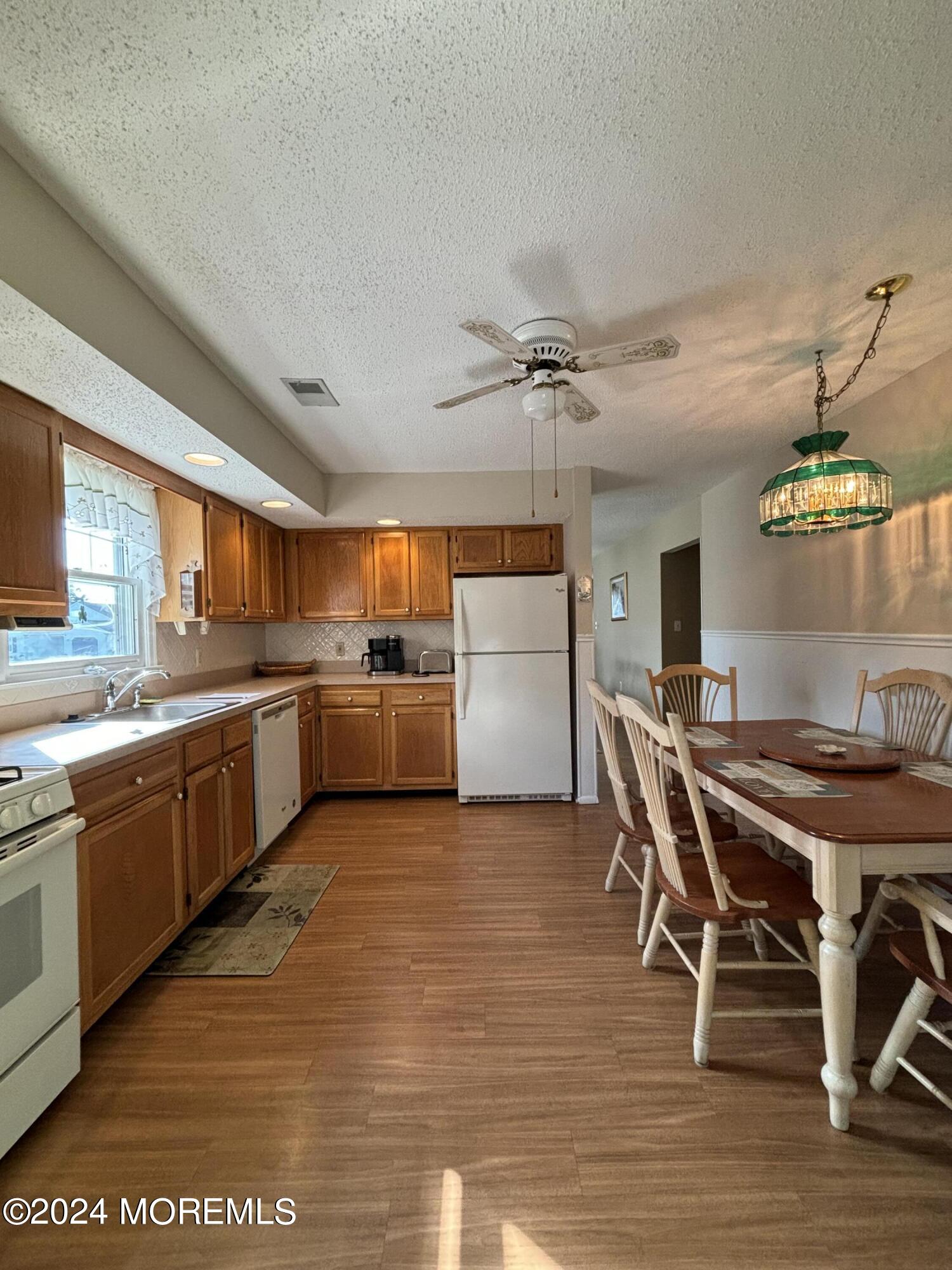 11 Springhill Drive Brick, NJ 08724 - Photo 4 of 15 a kitchen with stainless steel appliances kitchen island granite countertop a table chairs sink and cabinets