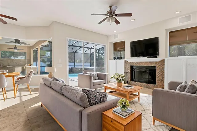 an empty room with a ceiling fan and kitchen view