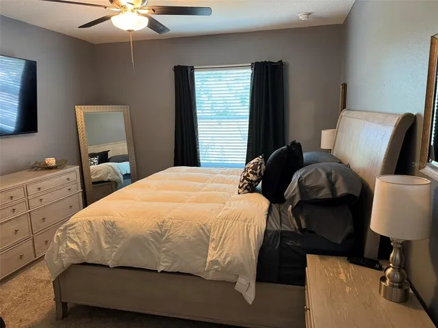 a bedroom with a bed and a lamp on dresser