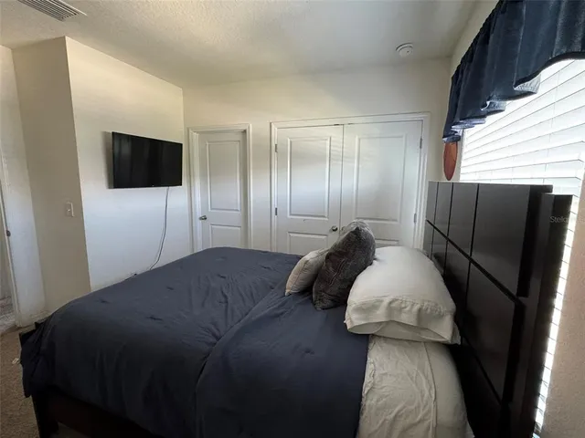 a bedroom with a bed and a television