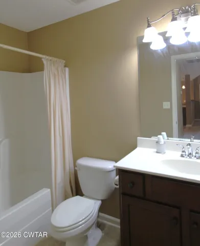 a bathroom with a sink a toilet a mirror and shower