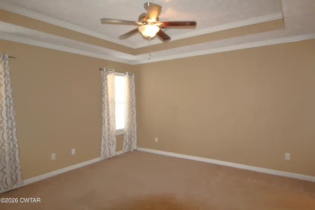an empty room with windows and a ceiling fan