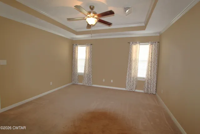 an empty room with windows and a chandelier fan