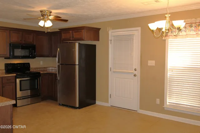 a kitchen with kitchen island a counter top space appliances and a ceiling fan