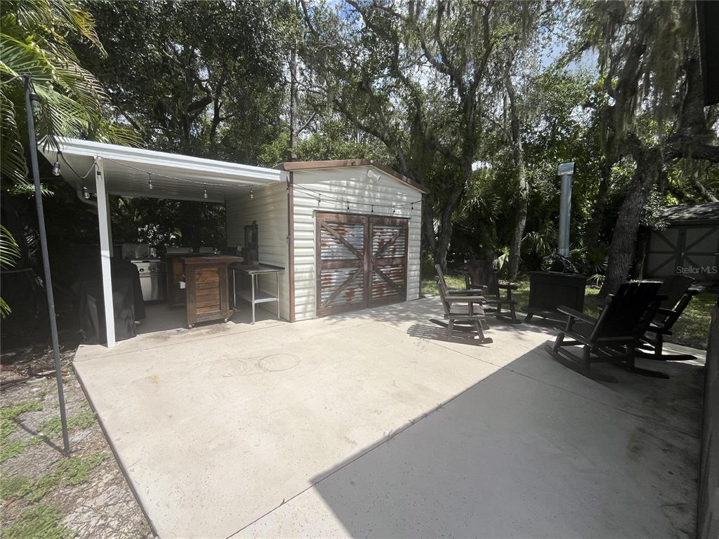 112 East Appaloosa Trail River Ranch, FL 33867 - Photo 5 of 10 a view of a patio with table and chairs a barbeque with wooden fence and floor