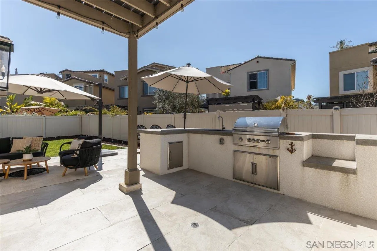 3008 Estero Road Carlsbad, CA 92010 - Photo 28 of 47 a kitchen with stainless steel appliances kitchen island a table and chairs in it
