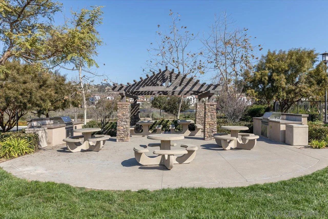 3008 Estero Road Carlsbad, CA 92010 - Photo 38 of 47 a view of a patio with table and chairs potted plants and a large tree