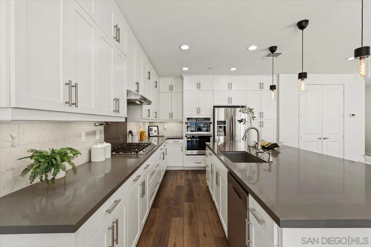 3008 Estero Road Carlsbad, CA 92010 - Photo 7 of 47 a kitchen with stainless steel appliances granite countertop sink stove and refrigerator