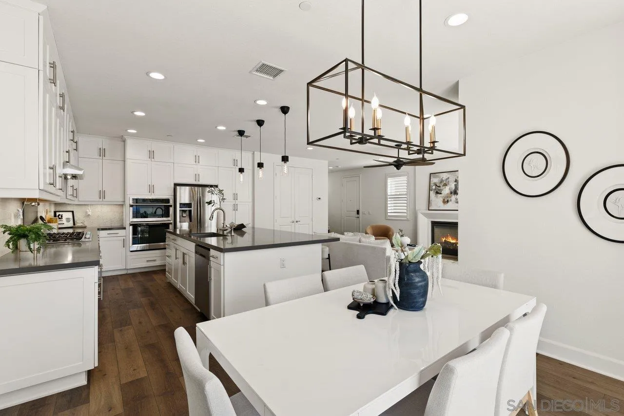 3008 Estero Road Carlsbad, CA 92010 - Photo 9 of 47 a kitchen with stainless steel appliances kitchen island granite countertop a table chairs and a stove