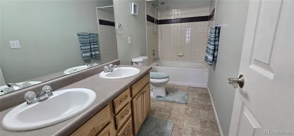 a bathroom with a granite countertop sink a toilet a mirror and shower