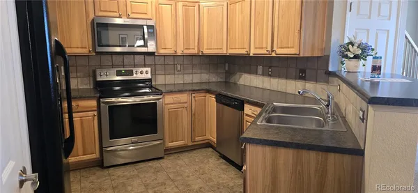 a kitchen with granite countertop a sink a stove and cabinets