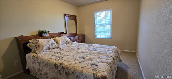 a large bed sitting in a bedroom next to a window