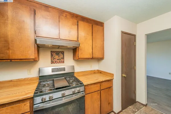 a kitchen with wooden cabinets and a stove top oven