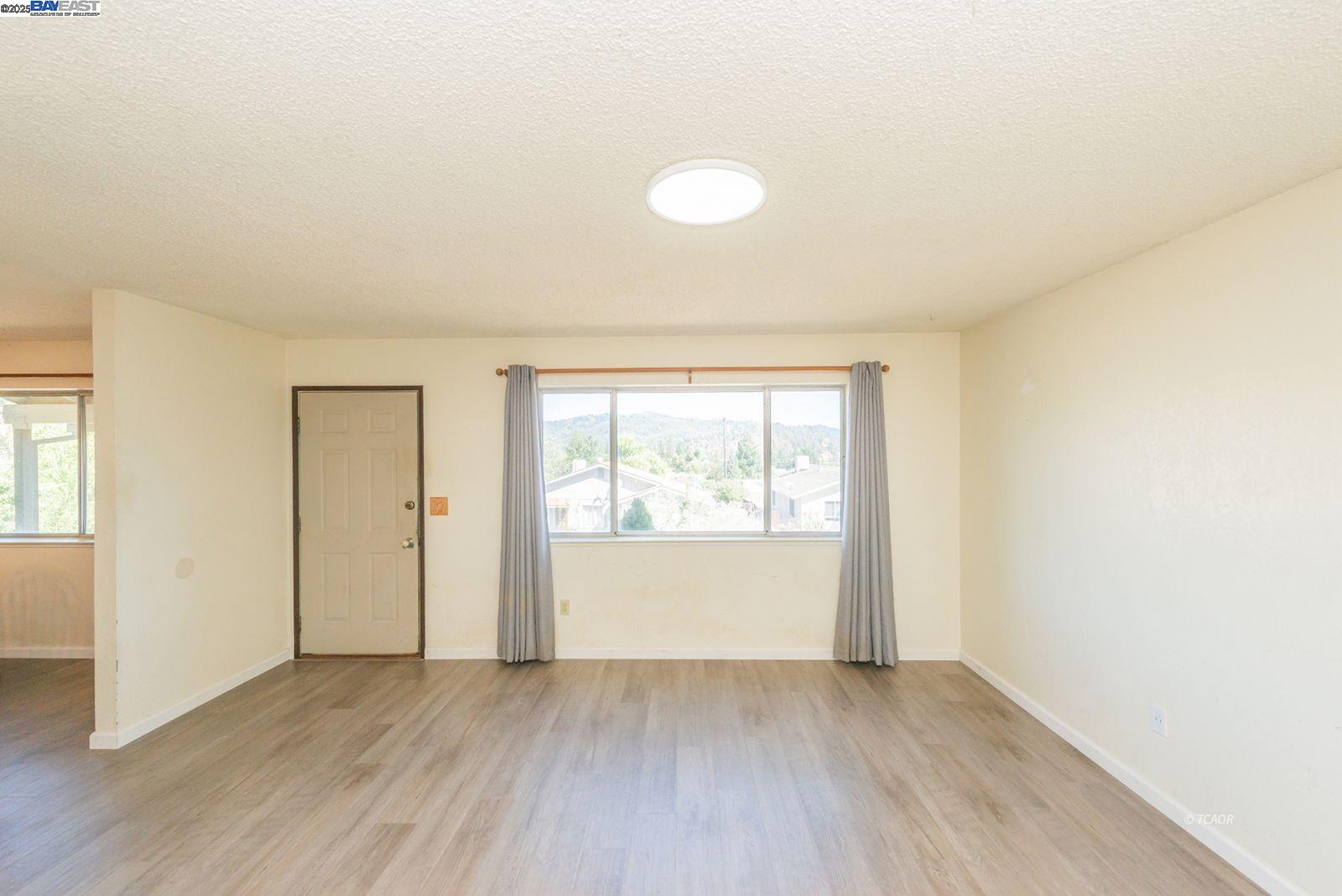 10 2nd Avenue Lewiston, CA 96052 - Photo 8 of 38 an empty room with wooden floor and windows