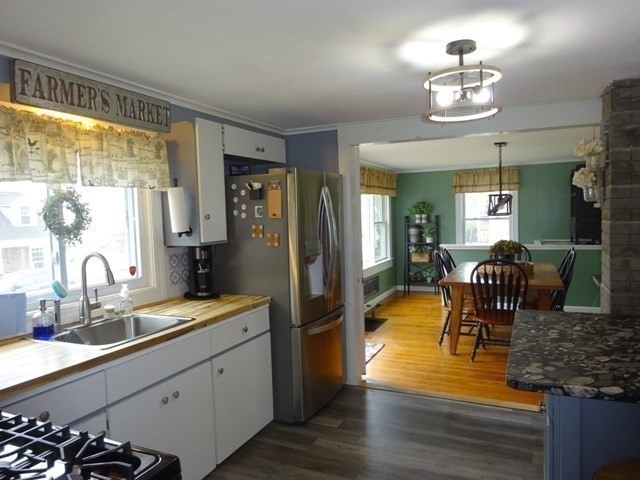 15 Cranberry Road Sagamore, MA 02561 - Photo 7 of 42 a kitchen with stainless steel appliances granite countertop a refrigerator a stove a sink dishwasher a dining table and chairs with wooden floor