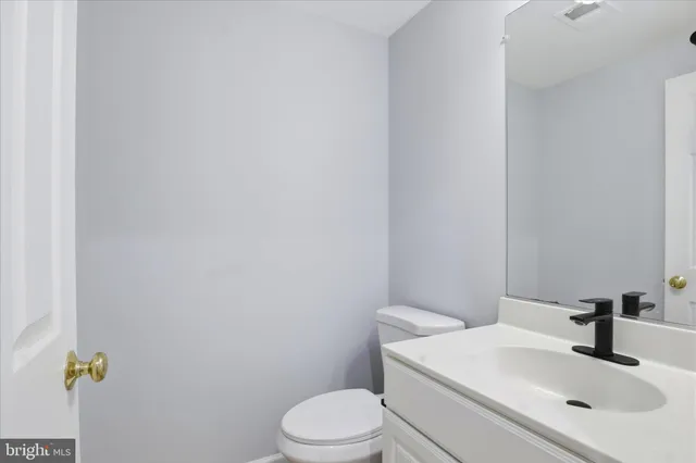 a view of an empty room with fireplace stairs and a chandelier fan
