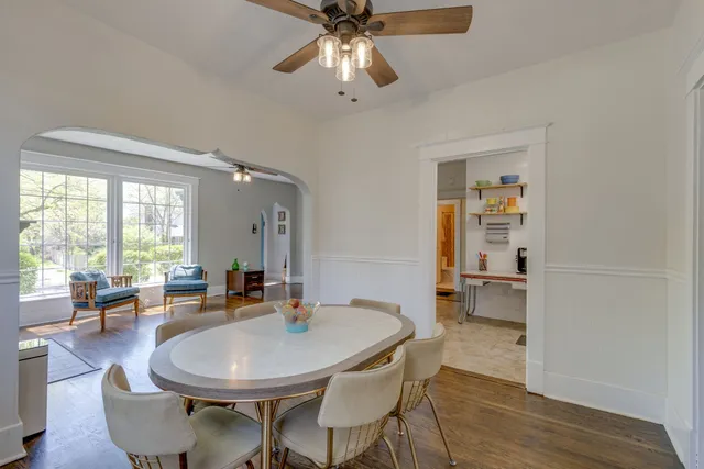 a dining room with furniture a chandelier and wooden floor