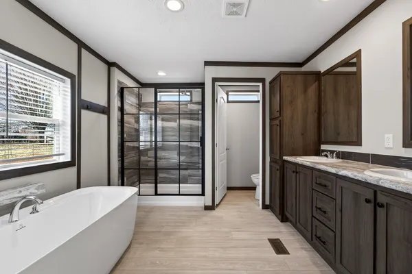 a spacious bathroom with a tub mirror and sink