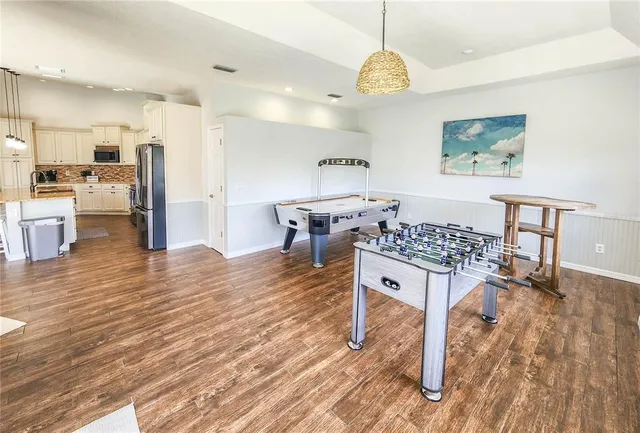 a spacious bathroom with a granite countertop sink a mirror and wooden floors