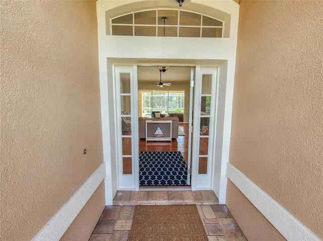 a living room with furniture large window and wooden floor