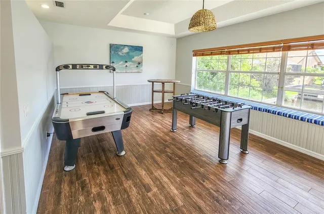 a dining room with wooden floor a chandelier a wooden table and chairs