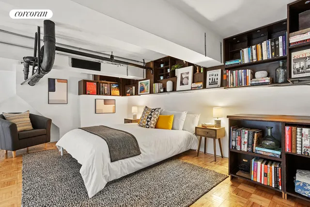 a bedroom with a bed furniture and a book shelf