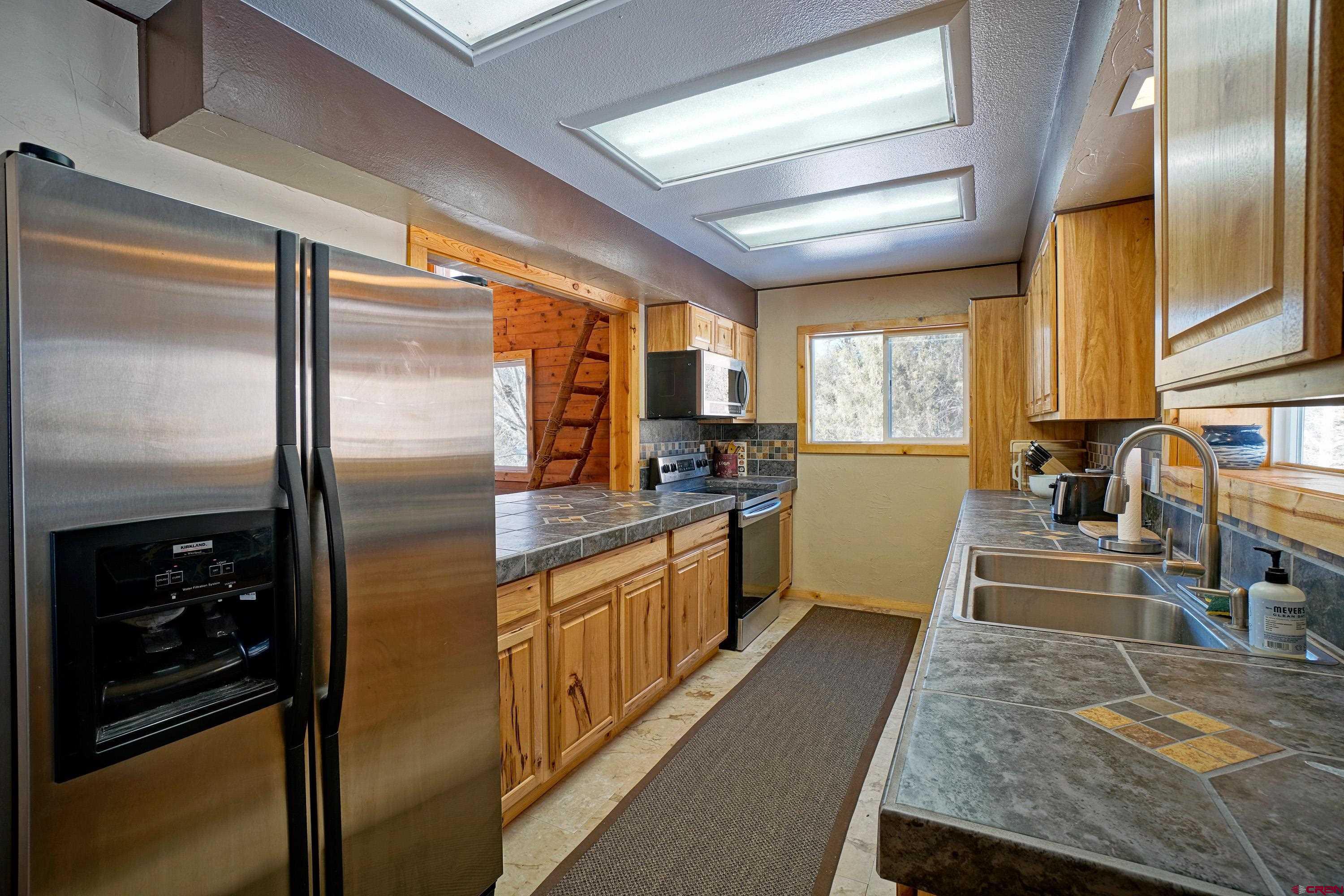 448 Whitehouse Vista Lane Ridgway, CO 81432 - Photo 16 of 34 a kitchen with stainless steel appliances granite countertop a refrigerator a stove and a sink