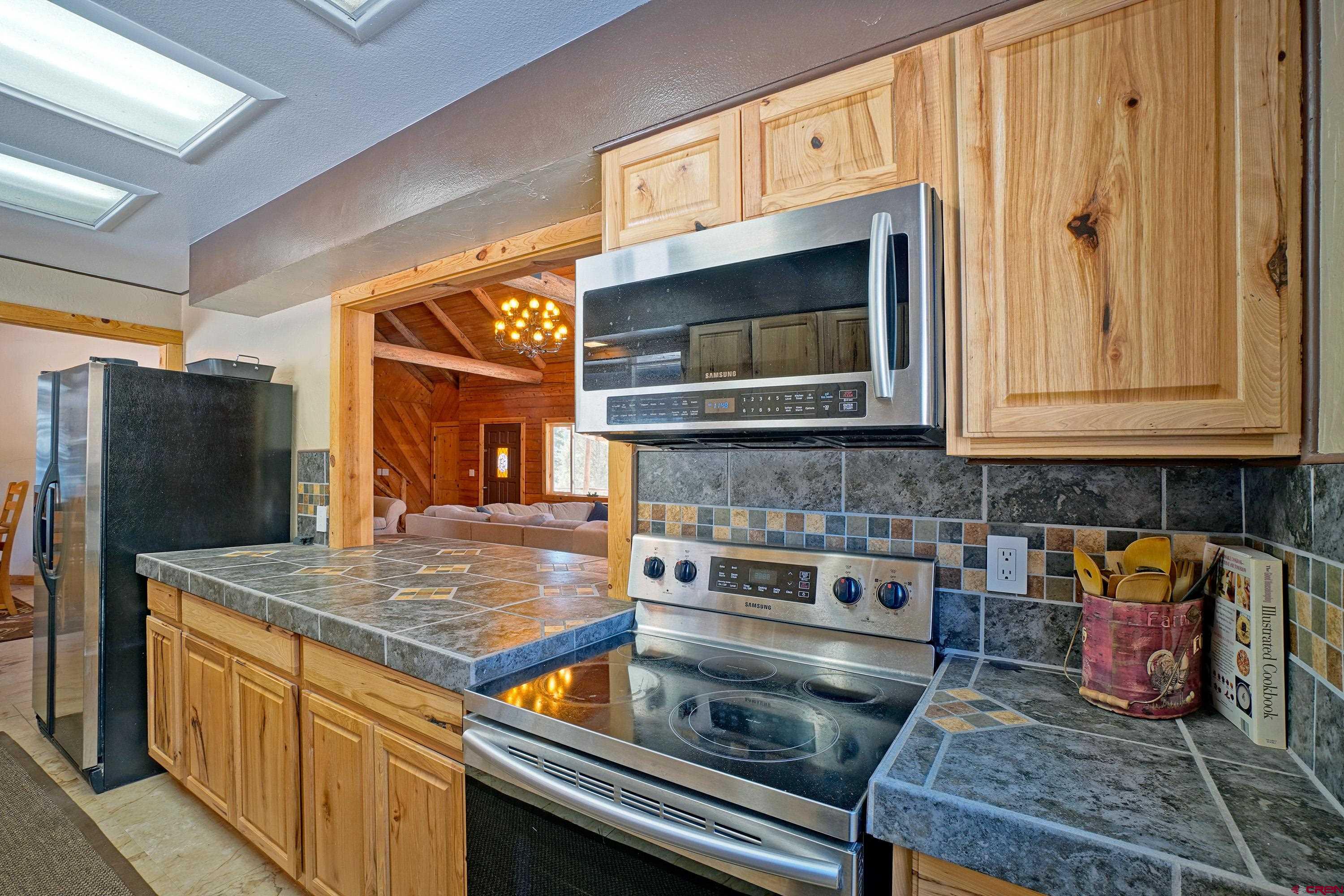 448 Whitehouse Vista Lane Ridgway, CO 81432 - Photo 18 of 34 a kitchen with stainless steel appliances granite countertop a stove and a microwave