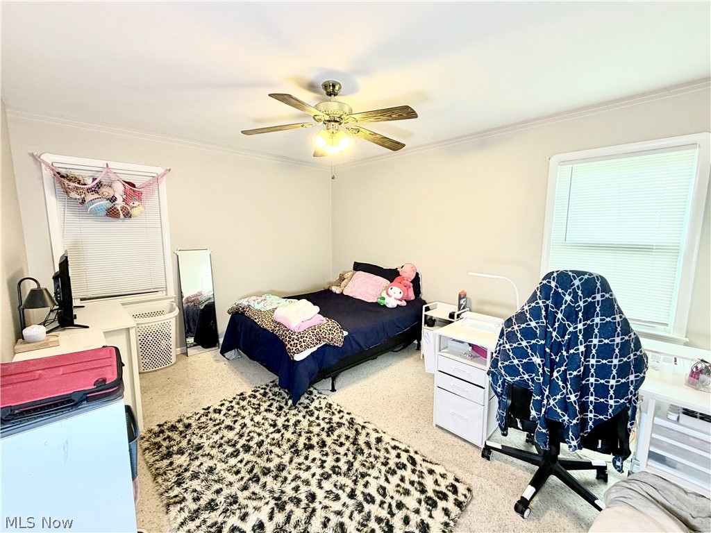 32125 Densmore Road Willowick, OH 44095 - Photo 16 of 23 Carpeted room featuring a ceiling fan with integrated lighting, crown molding, and two windows with blinds