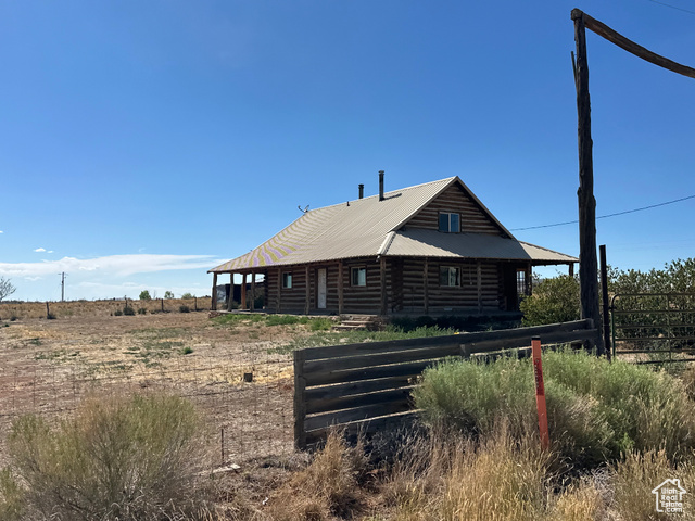 View of side of home featuring log exterior and a metal roof