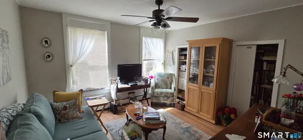a living room with furniture a flat screen tv and a window