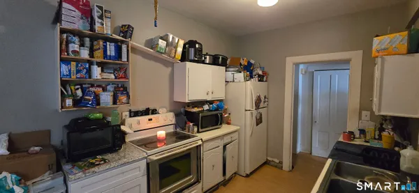 a kitchen with stainless steel appliances a stove and a bookshelf