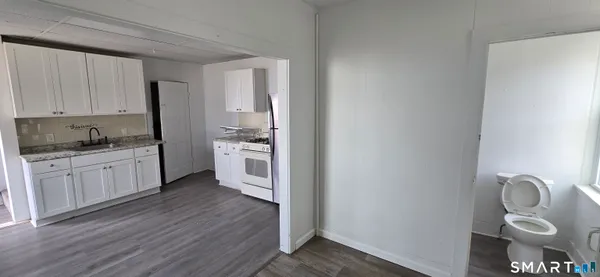 a kitchen with a refrigerator and white cabinets