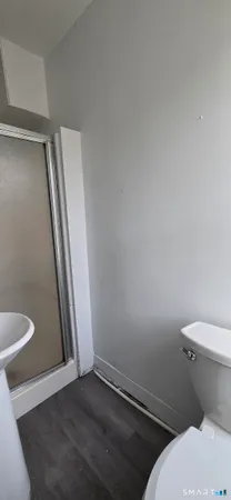 a white toilet sitting next to a shower