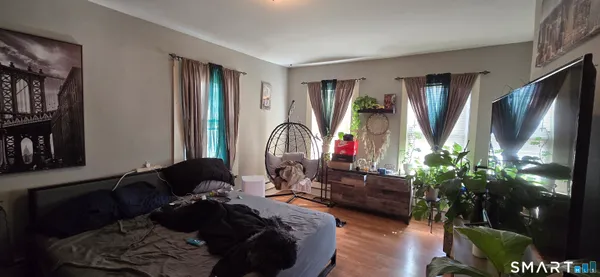 a living room with furniture a flat screen tv and a large window