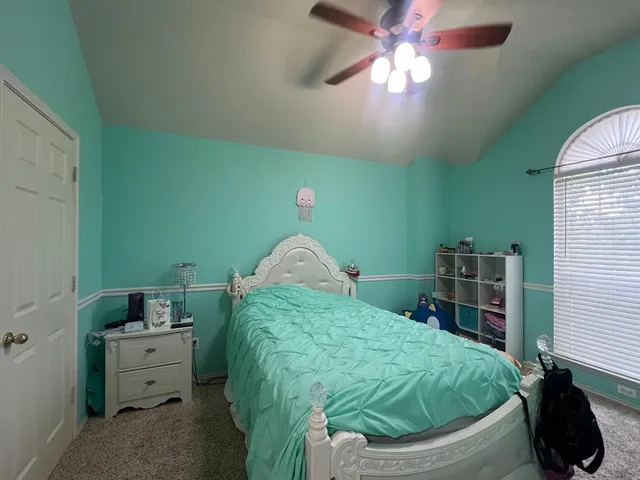 a spacious bedroom with a bed and a chandelier