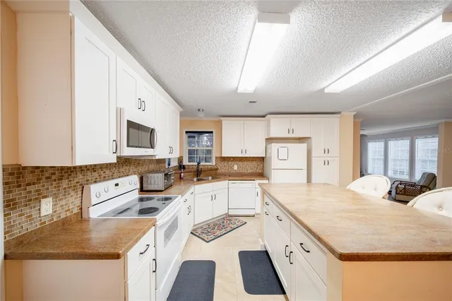 a large kitchen with stainless steel appliances granite countertop a lot of counter space and wooden floor