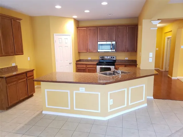 a kitchen with stainless steel appliances granite countertop a stove a sink and a microwave